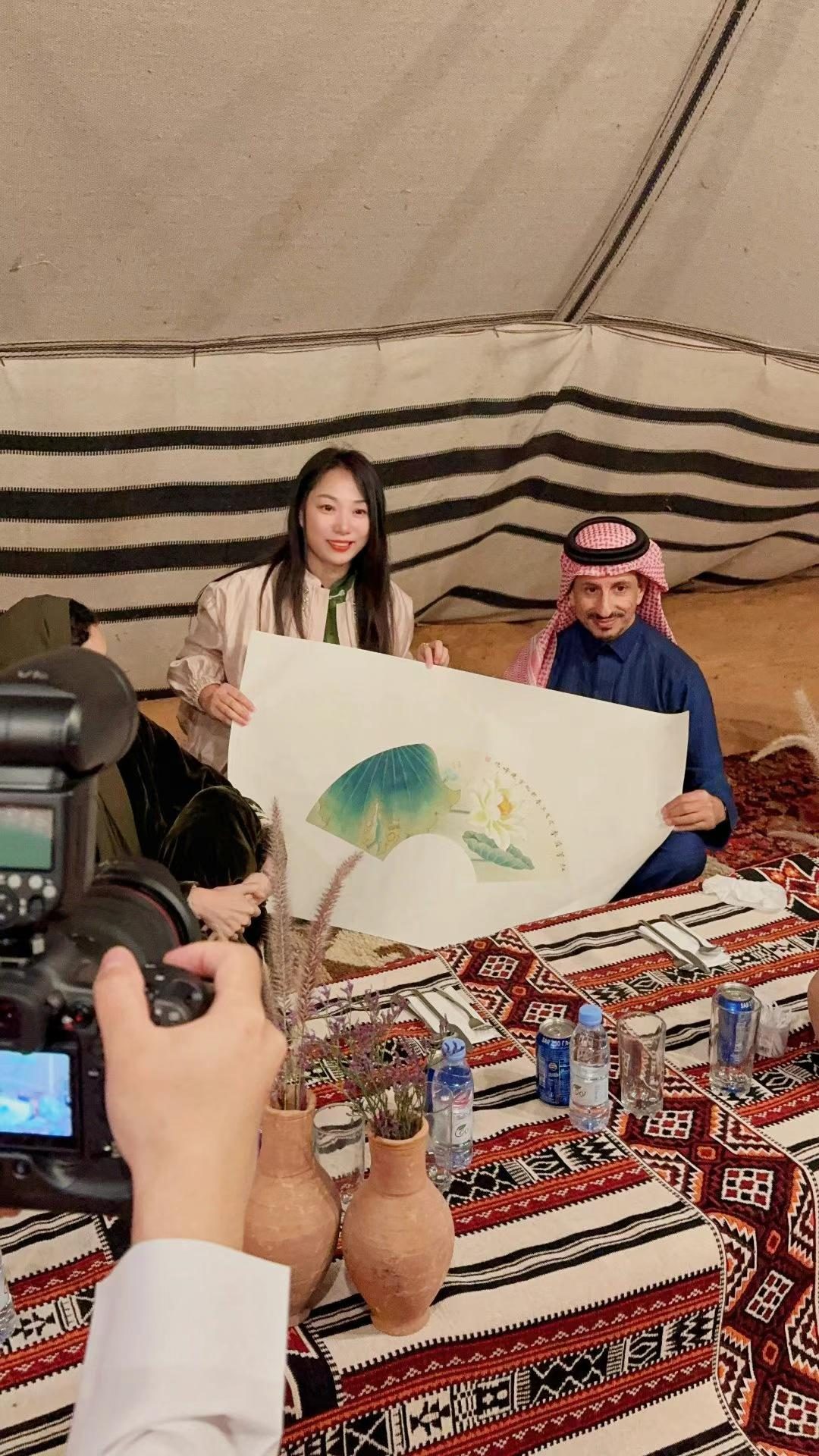 周东妮在沙漠营地文化交流环节向沙特友人赠送中国画作品